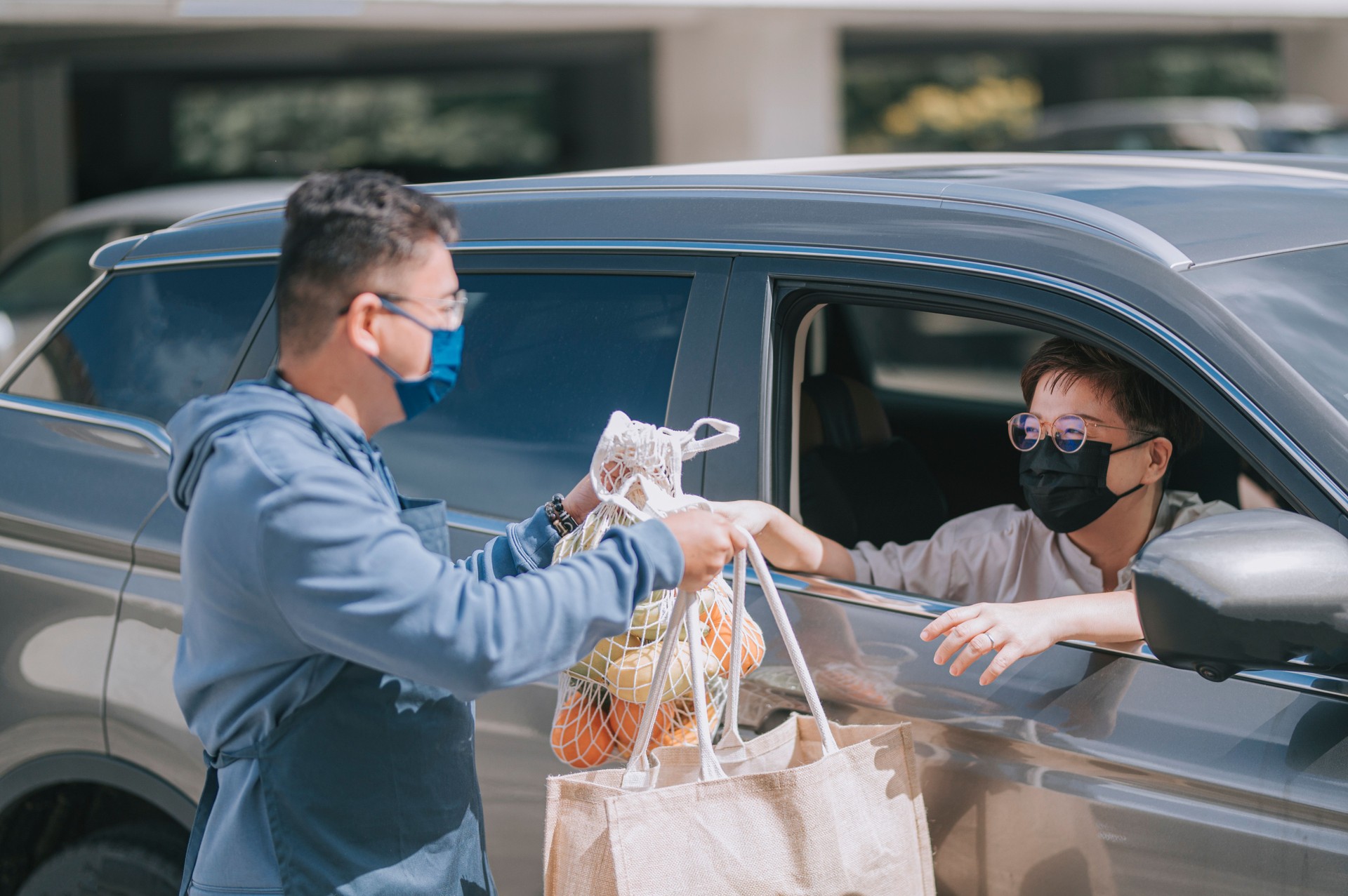 asian chinese mid adult woman Mature woman picking her to go order from her car at a Curbside pickup